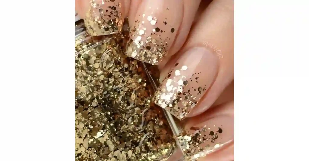 27. Gold glitter ombre tips and nude acrylic nails