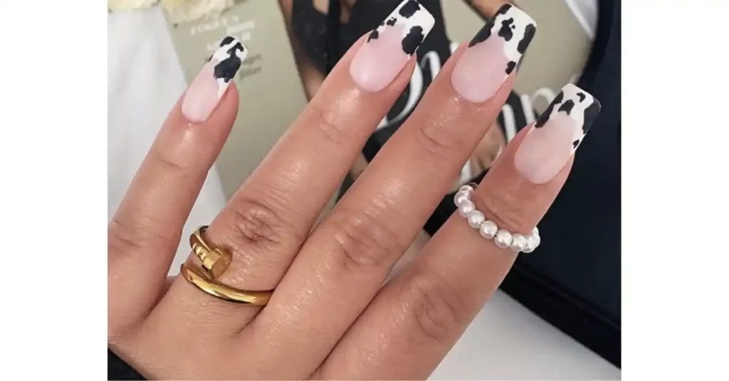 59. Nude acrylic nails with cow print French tips